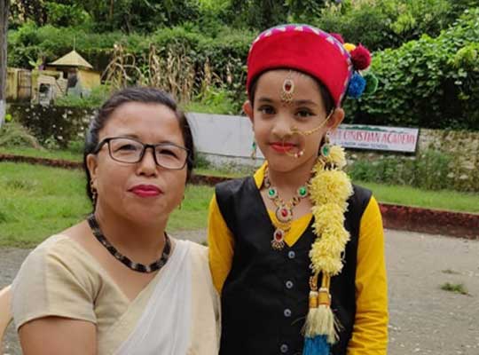 Principal with a student who participate fancy dress program